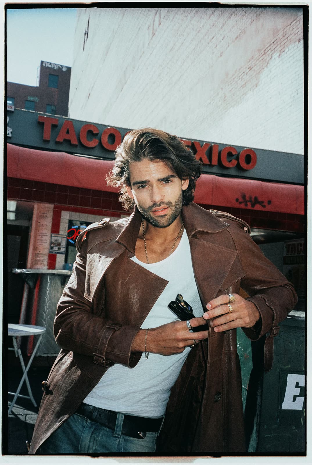 Man in a brown leather jacket outside a taqueria, film border — RENAN, by Kenneth Kemp