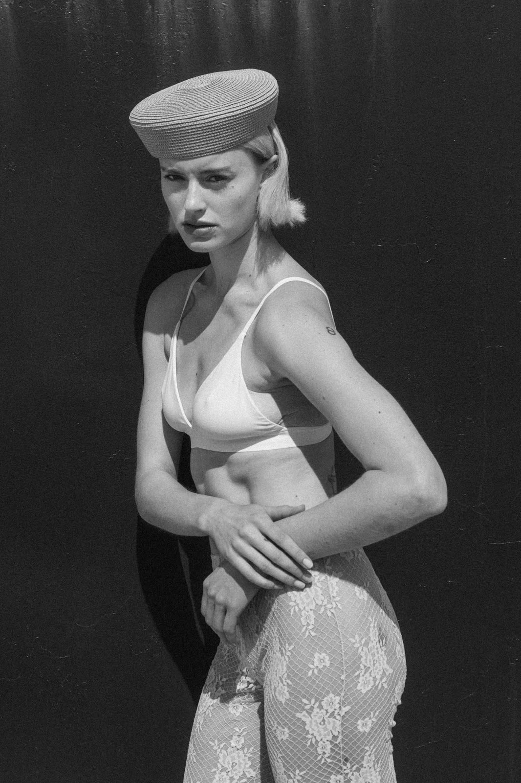 Black and white frame in a white bra, patterned trousers and a cap — GLORIA, by Kenneth Kemp