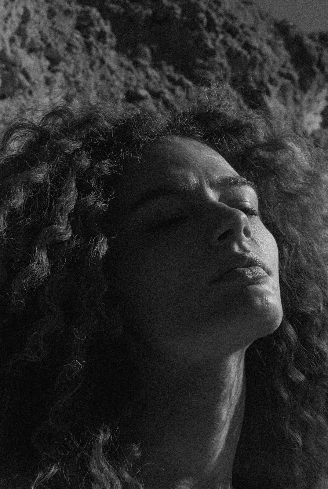 Black and white close frame, head tilted back against rock — MASCAVO, by Kenneth Kemp
