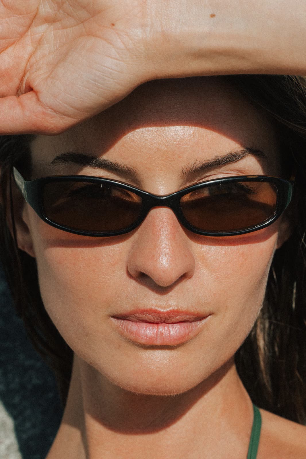 Close portrait in sunglasses with a hand shading the eyes — CRISTINA, by Kenneth Kemp